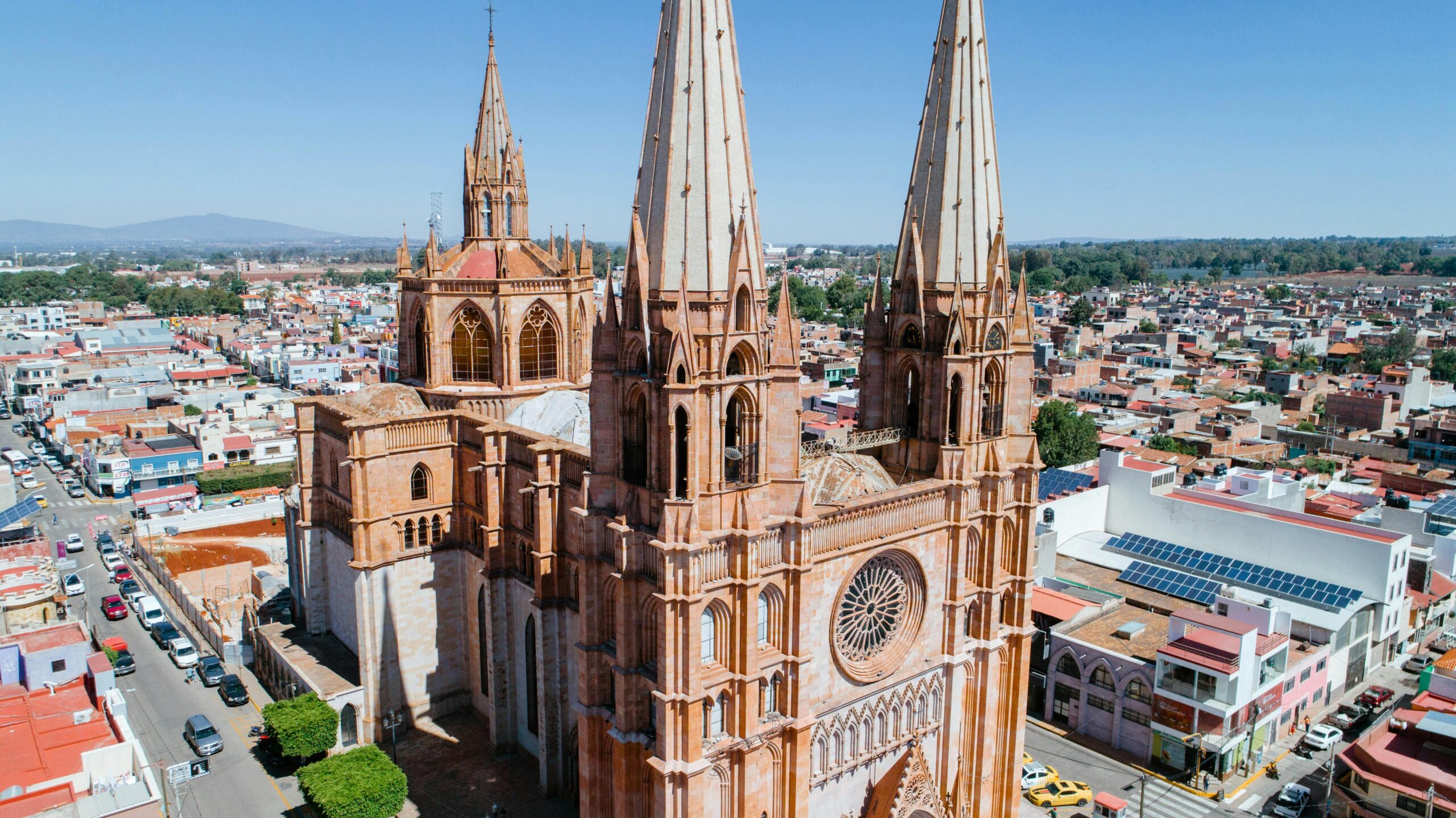 Aerial view of a stunning Gothic-style cathedral amidst a vibrant Mexican cityscape.